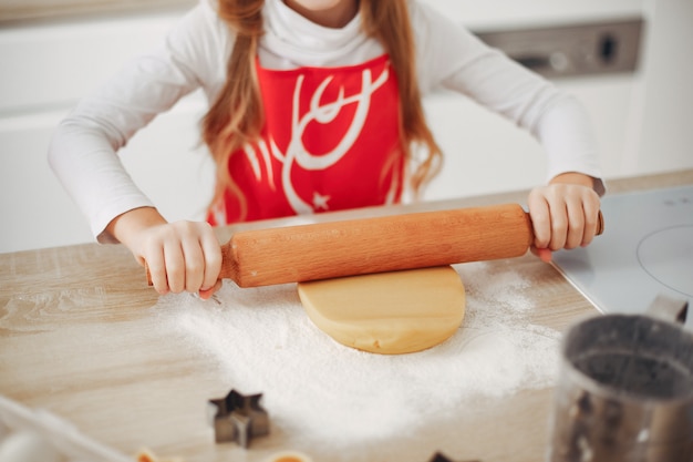 Petite fille cuire la pâte pour les cookies