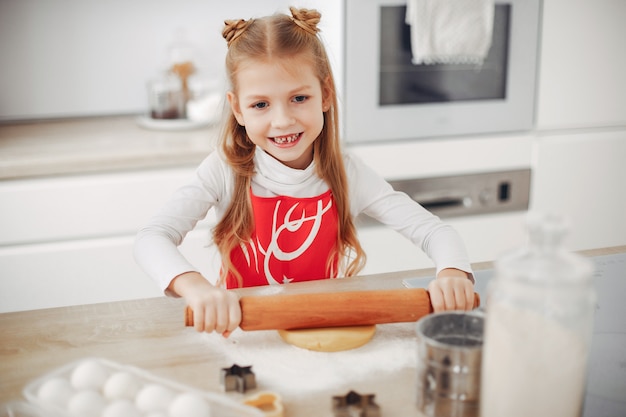 Petite fille cuire la pâte pour les cookies