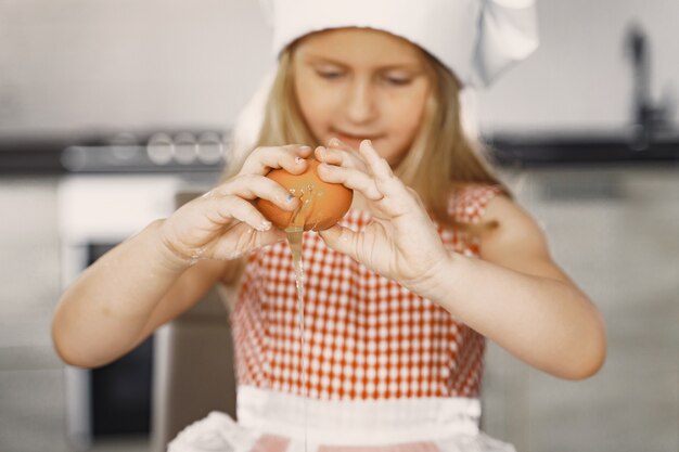 Petite fille cuire la pâte pour les cookies