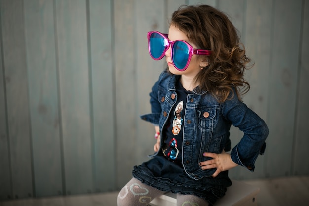 Petite fille dans de grandes lunettes de soleil