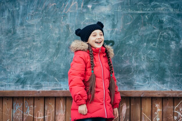 Petite fille dans le parc automne se tient à la commission scolaire.