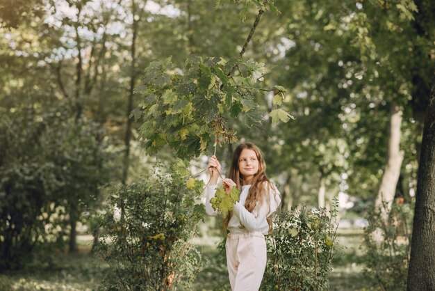 Petite fille dans un parc dans une blouse blanche