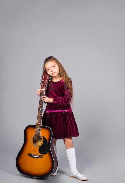 Photo gratuite petite fille debout avec une guitare acoustique