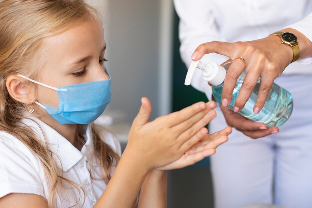 Petite fille désinfectant ses mains