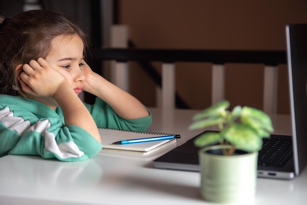 Petite fille devant le concept d'étude d'écran d'ordinateur portable