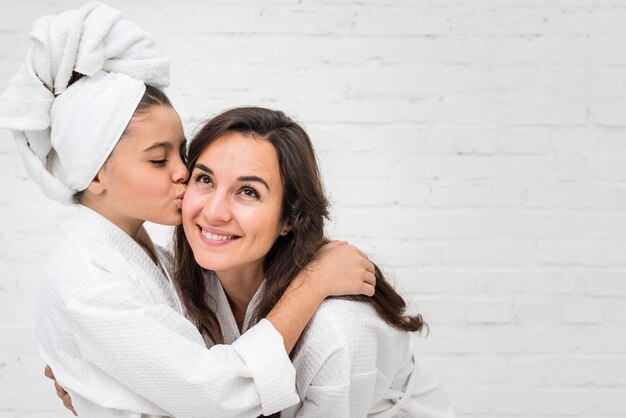 Petite fille embrassant sa mère sur la joue