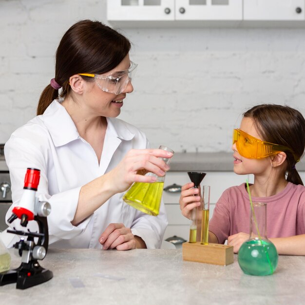 Petite fille et enseignante faisant des expériences scientifiques avec des tubes à essai