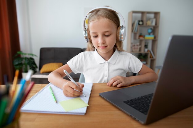 Petite fille faisant des cours en ligne à domicile