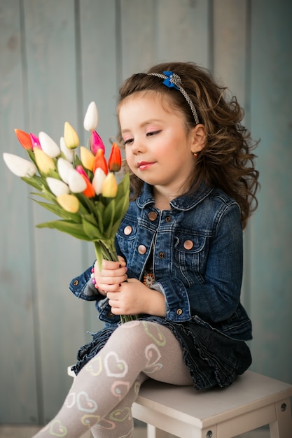 Petite fille avec des fleurs en studio