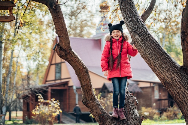 Petite fille grimpe à un arbre