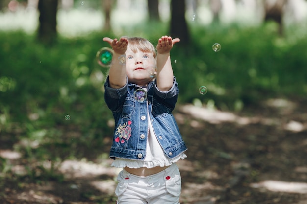 Petite fille jouant avec des bulles de savon à l&#39;extérieur