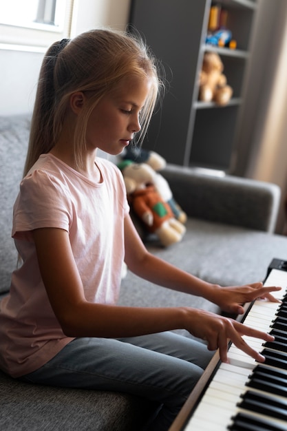 Petite fille jouant du clavier à la maison