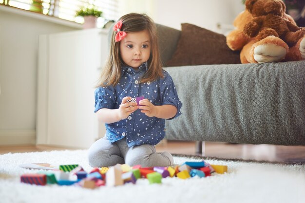 Petite fille jouant avec des jouets dans le salon