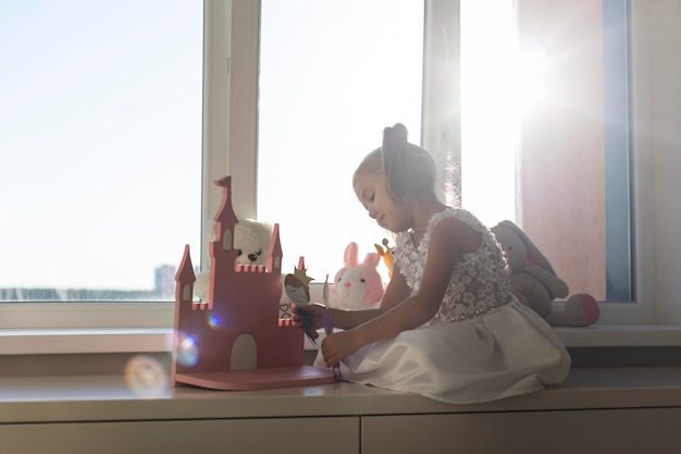 Photo gratuite petite fille jouant avec des marionnettes à la maison