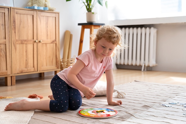 Petite fille jouant sur le sol avec un puzzle.
