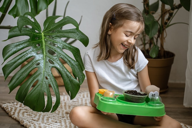 Une petite fille avec un kit bébé pour faire pousser une plante toute seule.