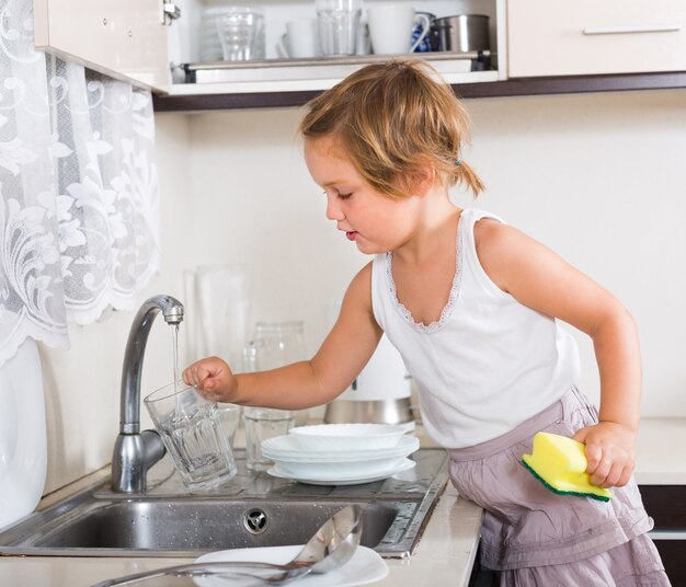 Petite fille à laver la vaisselle