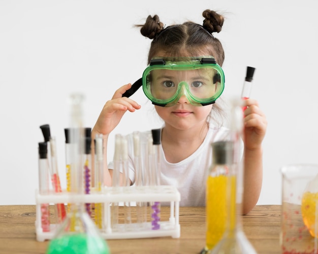 Photo gratuite petite fille avec des lunettes de sécurité en laboratoire