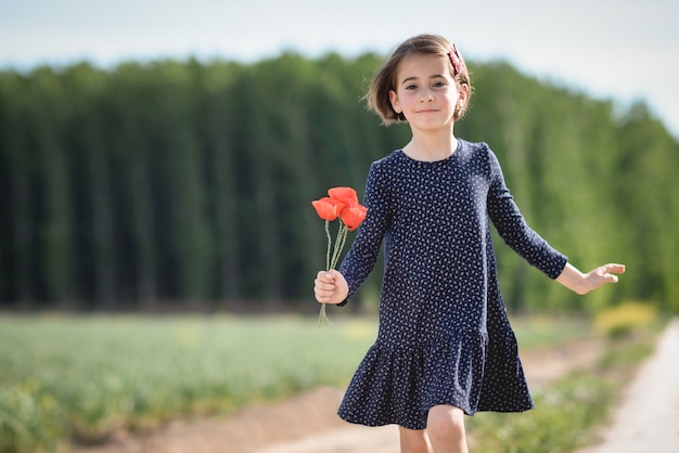 Petite fille marchant dans le champ de la nature portant une belle robe