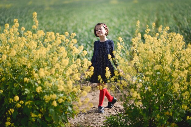 Petite fille marchant dans le champ de la nature portant une belle robe