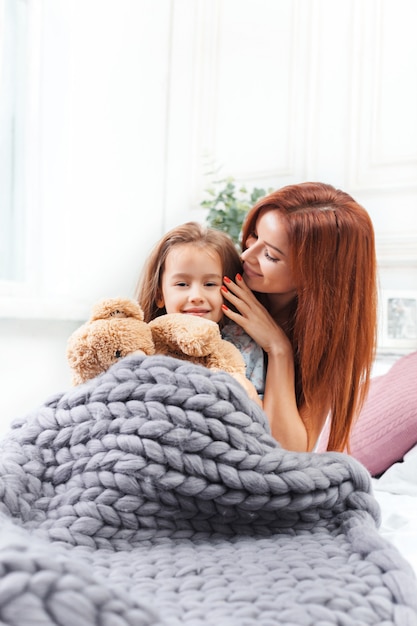 Une petite fille mignonne appréciant, jouant et créant avec des jouets avec la mère