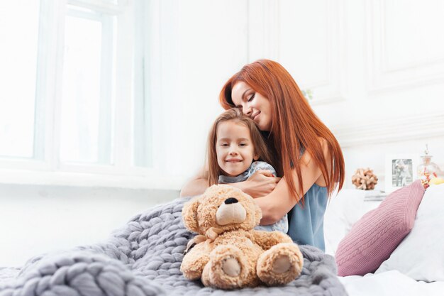 Une petite fille mignonne appréciant, jouant et créant avec des jouets avec la mère