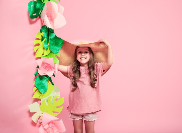 Petite fille mignonne en chapeau d'été sur fond de couleur