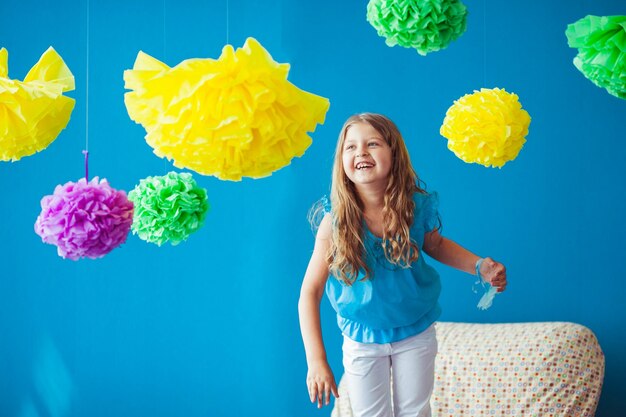 Petite fille mignonne jouant avec des fleurs colorées à l&#39;intérieur