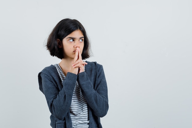 Petite fille montrant le geste des armes à feu en t-shirt