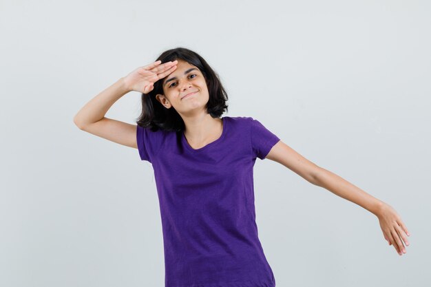 Petite fille montrant le geste de salut en t-shirt et à la fierté.