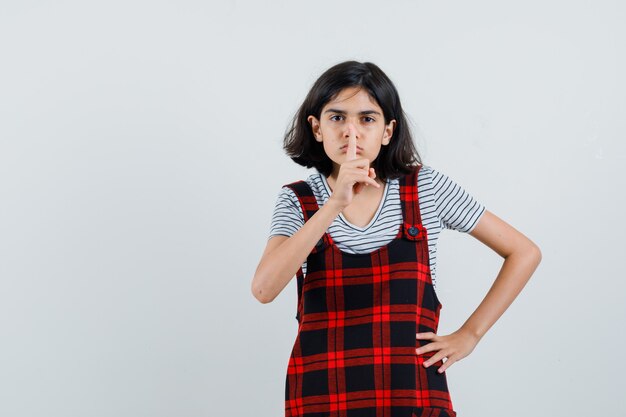 Petite fille montrant le geste de silence en t-shirt