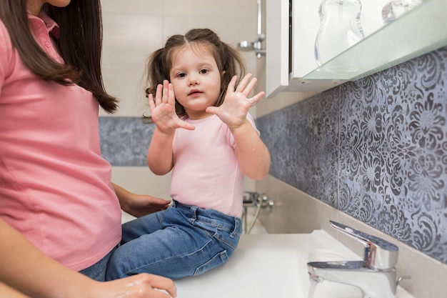 Petite fille montrant des mains propres