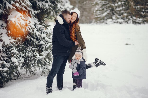 Petite fille avec des parents dans un parc d&#39;hiver