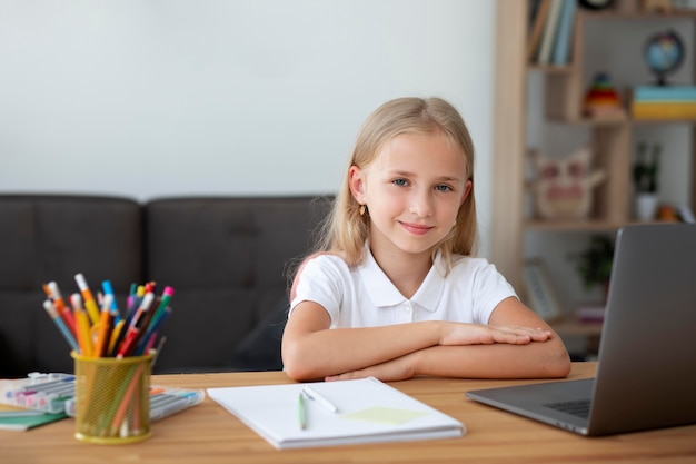 Photo gratuite petite fille participant à des cours en ligne à la maison