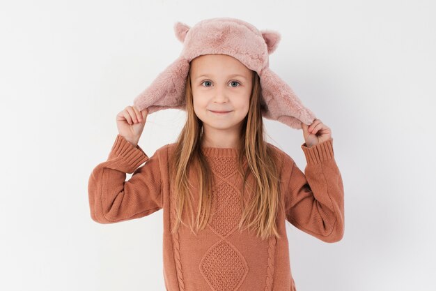 Petite fille payant avec son chapeau d'hiver