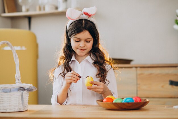 Petite fille peignant des oeufs pour Pâques