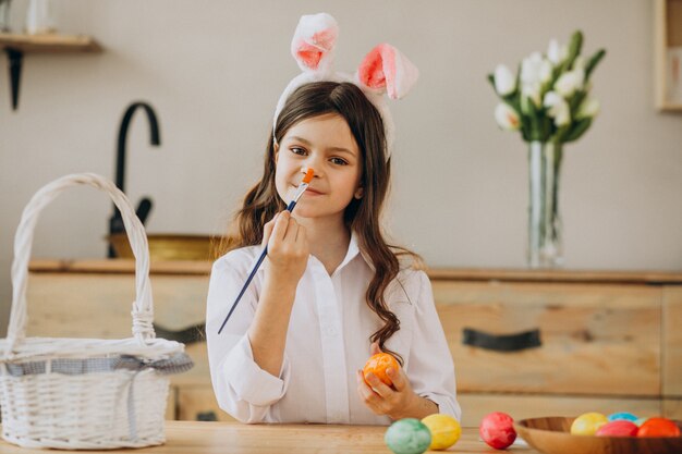 Petite fille peignant des oeufs pour Pâques