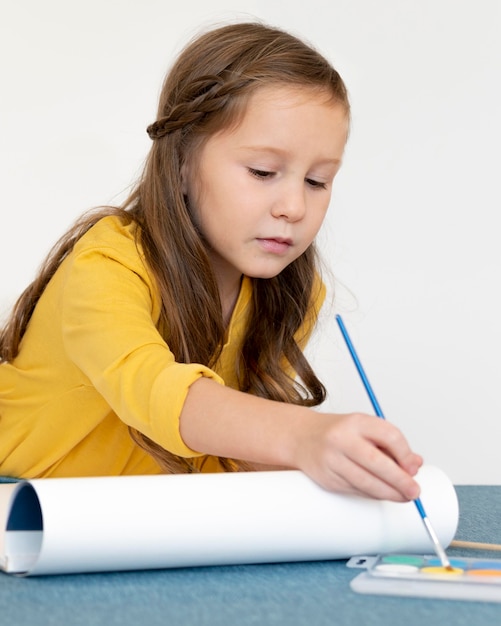 Petite fille peinture à l'aide de palette