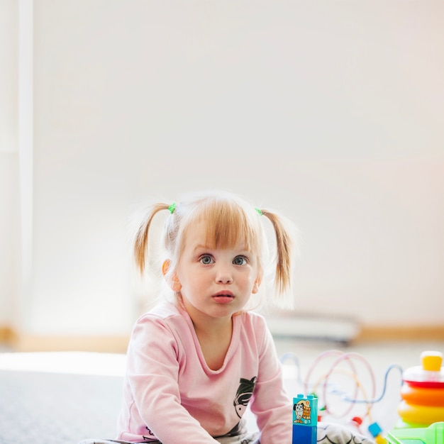 Petite fille pensive avec des jouets