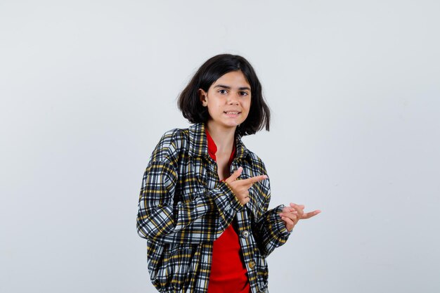 Petite fille pointant de côté en chemise, vue de face de la veste.