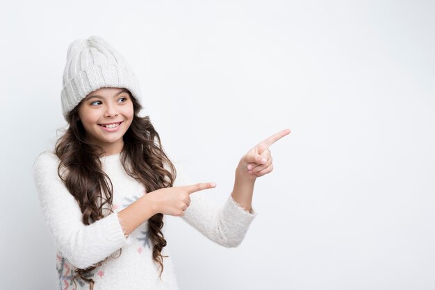 Petite fille pointant avec ses doigts vers la gauche