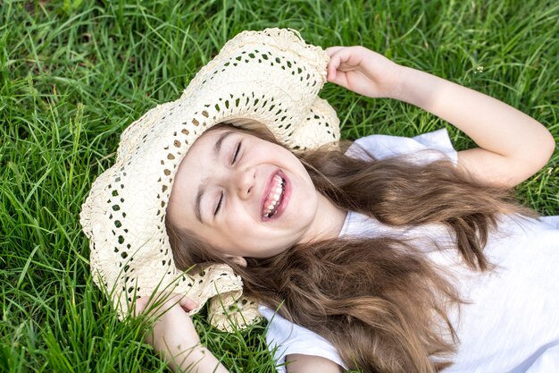 petite fille portant dans l'herbe. heure d'été et journée ensoleillée