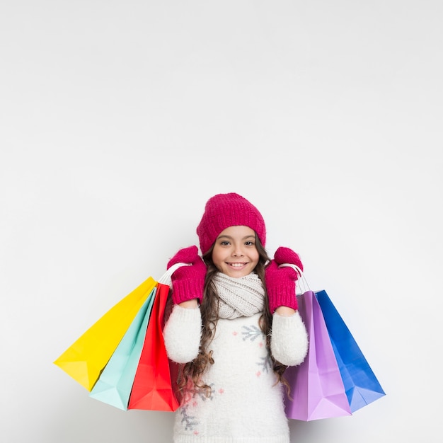 Petite fille portant des sacs shopping