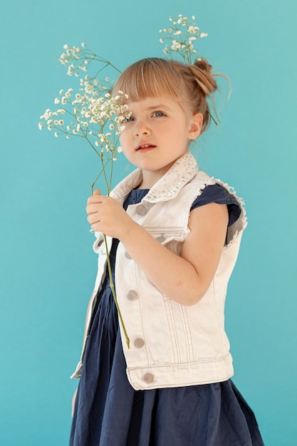 Petite fille posant avec des fleurs de printemps