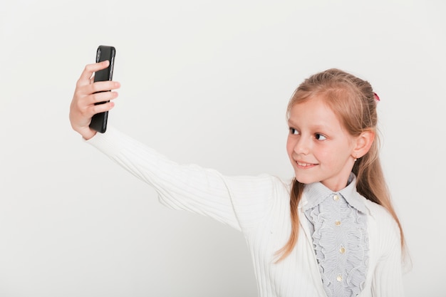 Petite fille prenant selfie avec smartphone