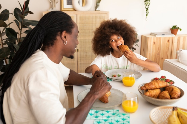 Petite fille prenant son petit déjeuner avec son père