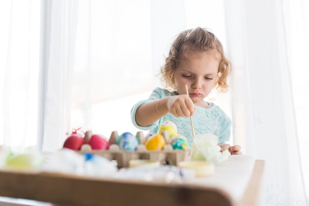 Petite fille prépare des oeufs pour Pâques