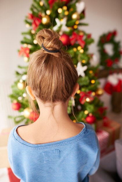 Petite fille regardant l'arbre de Noël