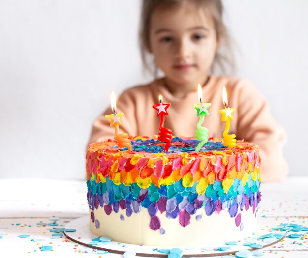 Une Petite Fille Regarde Un Beau Gateau D Anniversaire Concept De Surprise D Anniversaire Photo Premium