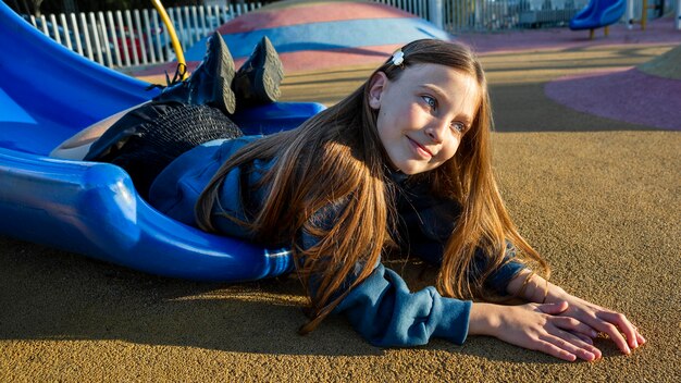 Petite fille restant au bord d'un toboggan